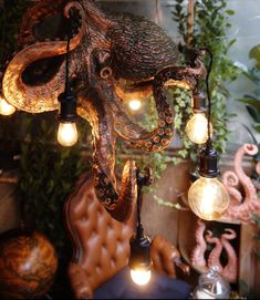 an octopus lamp hanging from the ceiling in a room filled with plants and other decorations