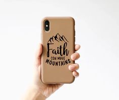 a person holding up a phone case with the words faith on it and mountains in black