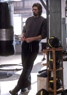 a man standing next to a punching bag