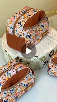 three pieces of luggage sitting on top of a white counter next to a cake box