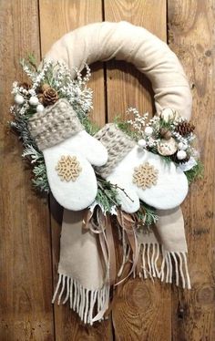 a wreath with stockings and pine cones hanging on a wooden door