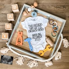 a baby's first birthday outfit and other toys on a wooden tray with the words, this fathers day off to order