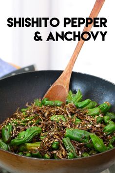 the stir fry is being cooked in a wok with green beans and sesame seeds