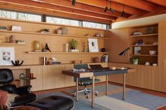 a home office with wood paneling and leather chairs