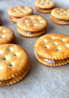 crackers with peanut butter and jelly filling on a baking sheet, ready to be baked