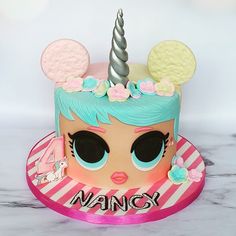 a close up of a cake on a table with a unicorn face and mouse ears