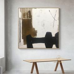 an abstract painting hangs on the wall above a table