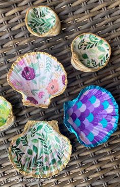 four decorative paper plates sitting on top of a wicker table