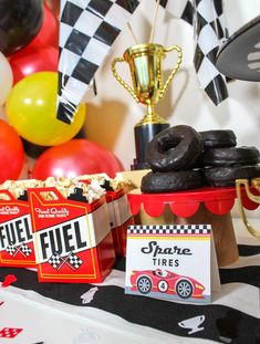 a table topped with boxes of donuts and cupcakes next to a trophy