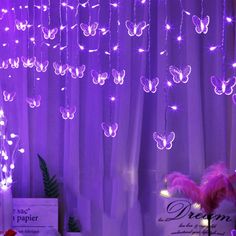 purple lights are hanging from the ceiling in front of curtains with pink flowers and butterflies on them