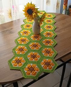 a crocheted table runner with sunflowers on it