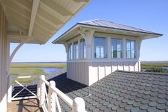 the roof of a house with a view of an ocean and marsh in the background