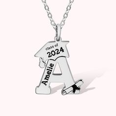 a silver necklace with an arrow and graduation date on it's front, hanging from a chain