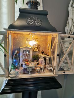 a miniature house is set up on top of a black table with white trimmings