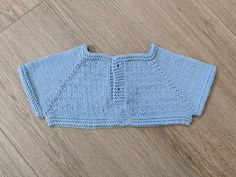 a blue knitted sweater laying on top of a wooden floor