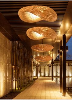 an outdoor walkway with bamboo lights hanging from the ceiling