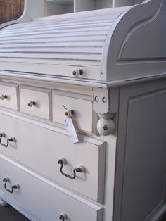 a white dresser with lots of drawers and knobs