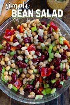 a glass bowl filled with beans and veggies next to a wooden cutting board