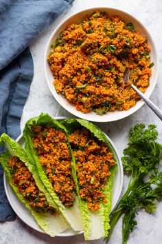 two bowls filled with lettuce and meat on top of a white tablecloth