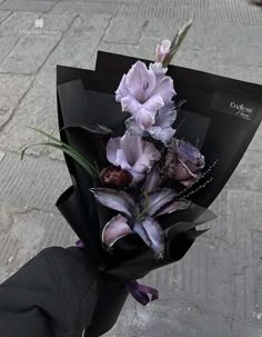 a bouquet of flowers is wrapped in black paper