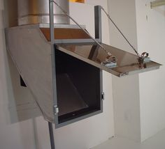 a large metal object hanging from the side of a wall in a room with white walls