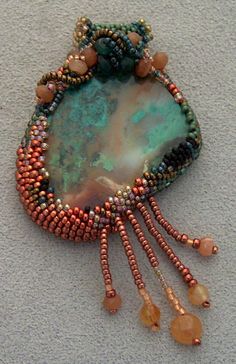 a beaded brooch with beads and other things on it's back end