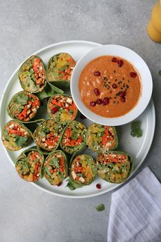 a white plate topped with green bell peppers next to a bowl of dipping sauce on top of it