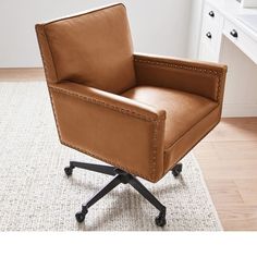 a brown leather office chair sitting on top of a white rug in front of a window