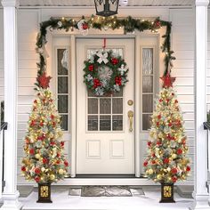 two christmas wreaths on the front door of a house