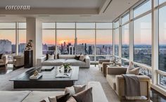 a living room filled with lots of furniture and large windows overlooking the cityscape