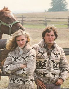 a man and woman standing next to a horse in a fenced - in area