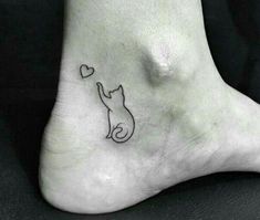 a small cat with a heart tattoo on the side of its foot is shown in black ink