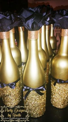 several gold wine bottles with black bows on them