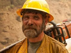 a man with a beard wearing a yellow hard hat