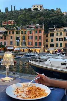 a plate of food on a table in front of some boats and buildings near the water