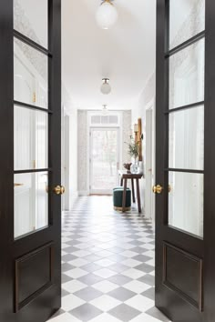 an open door leading into a hallway with checkered flooring