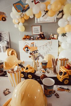 a birthday party with construction themed decorations and balloons