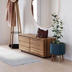 a wooden dresser sitting next to a round mirror on top of a hard wood floor