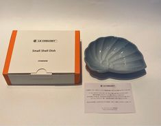 a small shell dish sits next to its box