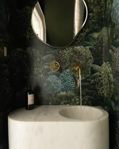 a white sink sitting under a bathroom mirror next to a wall mounted faucet