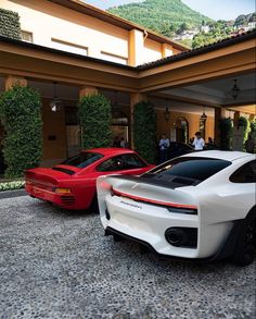 two sports cars parked in front of a house