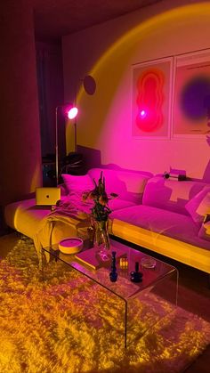 a living room filled with furniture and pink lighting