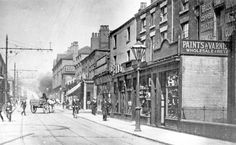 an old black and white photo of people walking down the street