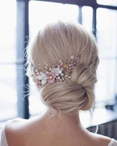 the back of a woman's head with flowers in her hair on top of it