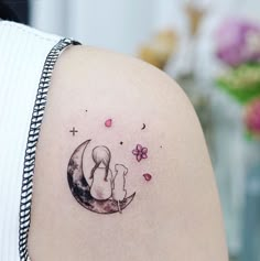 a woman with a tattoo on her shoulder is looking at the moon and stars in the sky