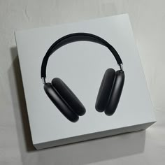 a pair of black headphones sitting on top of a white box