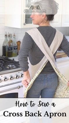 a woman standing in the kitchen with her back to the camera and holding an apron over her shoulder