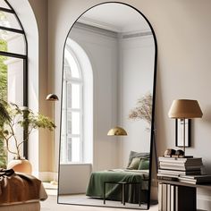 an arched mirror in a living room next to a couch and table with a lamp on it