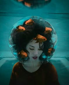 a woman with fish in her hair under water