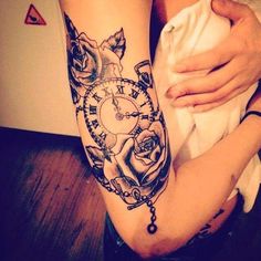 a woman's arm with a clock and roses tattoo on it